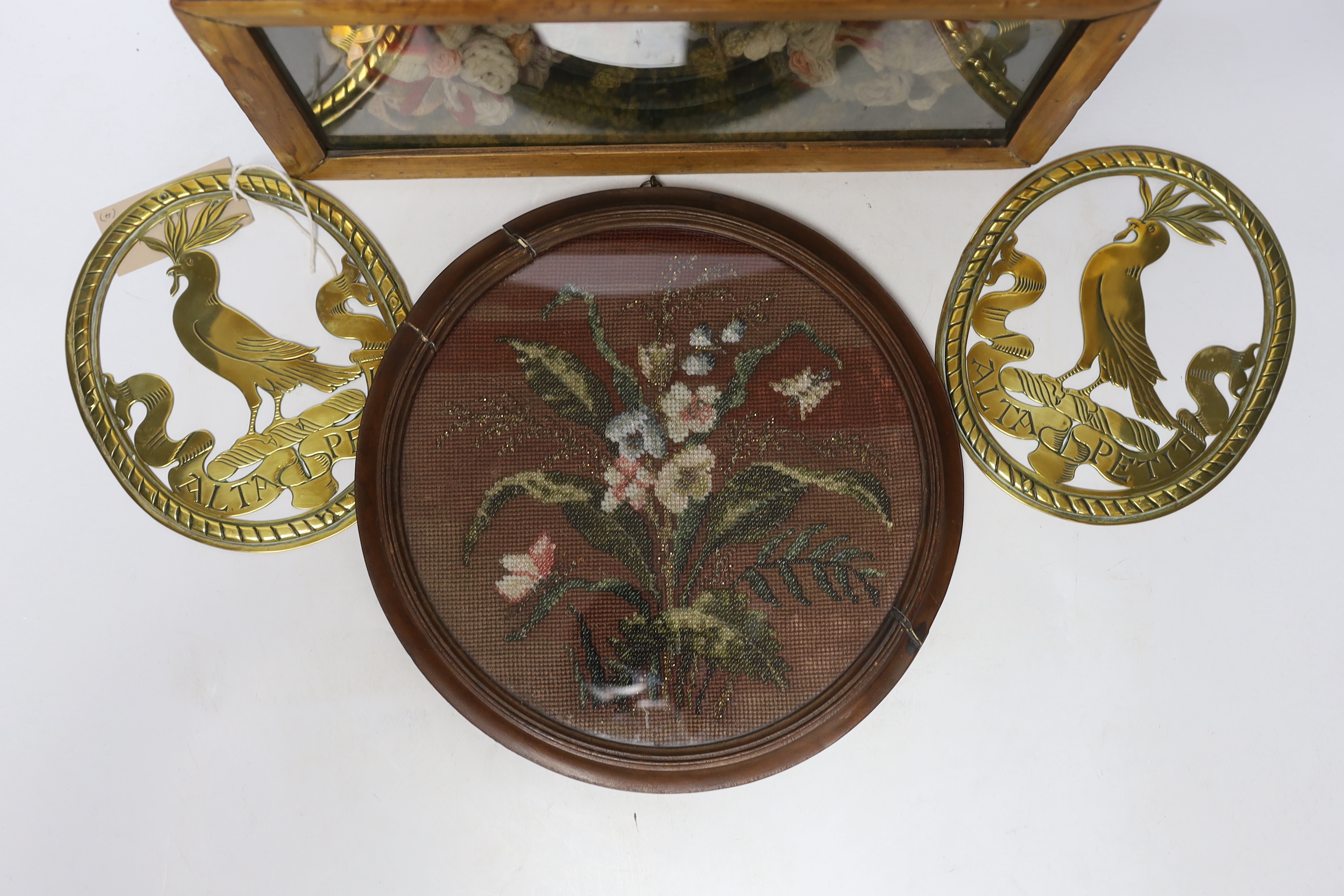 A pair of oval brass crests, a circular framed Berlin beadwork panel and a framed floral wool work diorama, diorama 3.5cm wide x 18cm high